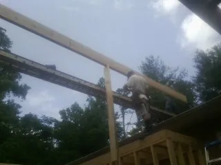 Carpenter setting a ridge beam over a new addition frame — Ice Dam Removal by Roofing Brothers in Shabbona