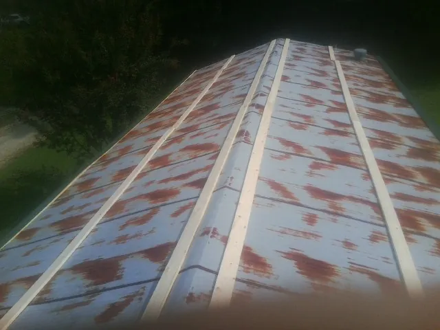 Rusted metal roof panels with new wood purlins before replacement — Storm Damage Roof Repair in Shabbona by Roofing Brothers