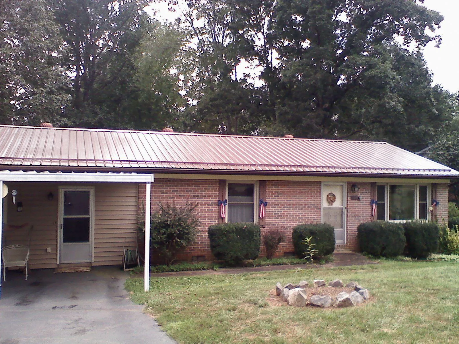 Bronze metal roof and carport on a brick ranch home — Roof Repair work by our crew in Shabbona