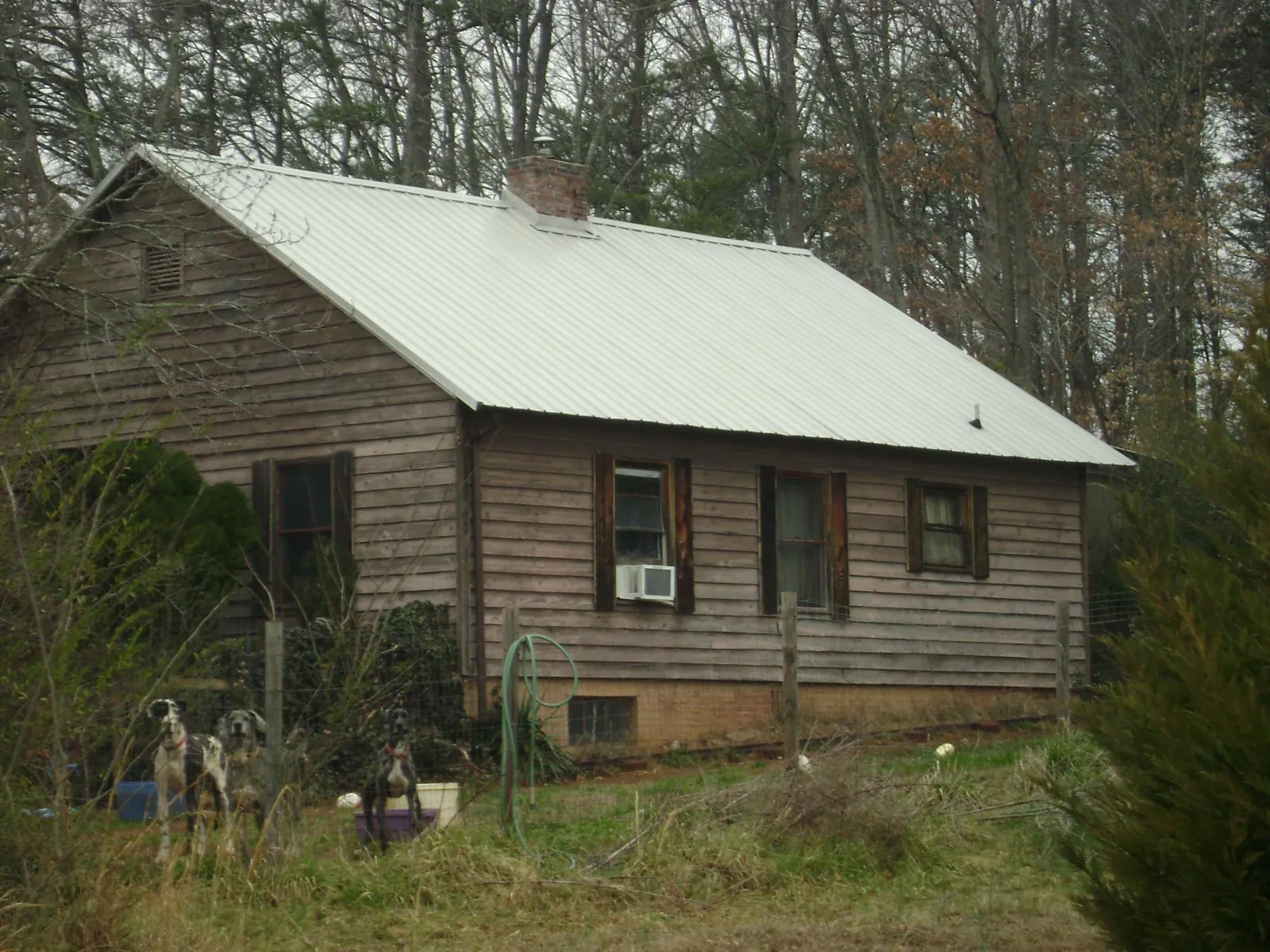 White metal roof on an old wood sided farmhouse, from a Metal Roof Installation job in Shabbona
